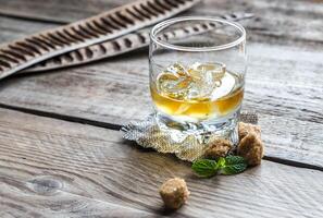 Glass of rum on the wooden background photo