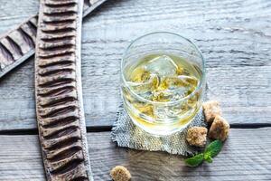 Glass of rum on the wooden background photo