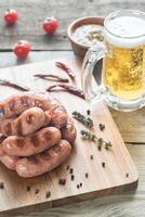 Grilled sausages with mug of beer photo