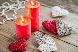 Hearts with burning candles on the wooden background photo