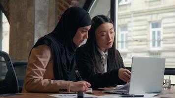 deux affaires femmes étudiant les filles multiracial femelle Multi-éthnique femme d'affaires asiatique coréen patron mentor femme enseigner Aidez-moi musulman islamique interne dans hijab collègues discuter les documents travail en équipe dans Bureau video