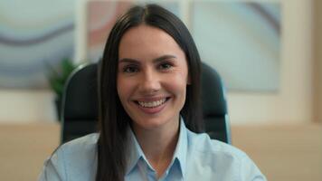 Female business portrait indoors happy cheerful Caucasian woman girl joyful positive toothy smile businesswoman entrepreneur leader ceo employer manager smiling at camera in office corporate workplace video