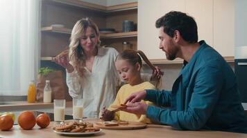 Lycklig caucasian familj medicinsk försäkring lån inteckning kreditera föräldrar barn unge dotter frukost tillsammans på kök Hem mat leverans friska äter choklad smörgås mor, far liten flicka video
