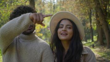 feliz sorridente despreocupado multiétnico casal dentro amor caminhando ao ar livre falando comunicar casado família homem mulher desfrutando romântico encontro dentro parque andar juntos Falando ternura afeição passeios turísticos video