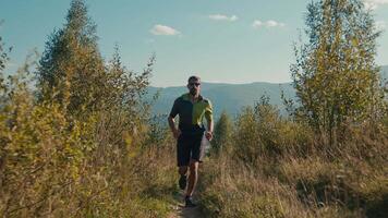 enfocado juguetón adulto caucásico masculino hombre chico corredor sprinter trotar ropa deportiva corriendo en sendero formación correr cardio ejercicio aptitud rutina de ejercicio deporte activo estilo de vida al aire libre montaña paisaje naturaleza video