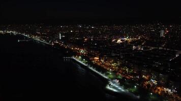 panorama- Drönare se av mersins stad horisont på natt. natt antenn antal fot som visar mersins upplyst stad horisont. Drönare fångar stad horisont av mersin upplyst på natt. video