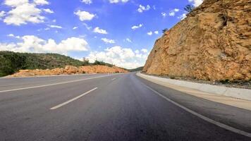 Car view on mountain highway, capturing serene journey along the asphalt path. Drive showcases mountain highway landscape, perfect for travelers. emphasizes beauty of traveling mountain highway video