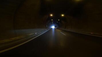 coche salidas túnel, revelador carretera. imágenes desde coche muestra túnel salida, enfatizando auto, túnel transición. capturas auto, túnel salida sobre carretera, exhibiendo auto, túnel viaje video