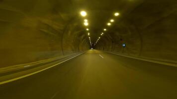 conduite par tunnel, capture voiture dans obscurité. expérience de conduite, voiture la perspective à l'intérieur tunnel Souligné. concentrer sur conduite, voiture navigation par Autoroute tunnel video