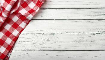 Old white vintage wooden table with red checkered tablecloth. photo