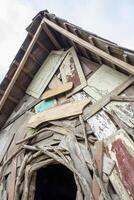 The walls of a traditional house are made of piles of old wooden sheets that look vintage photo