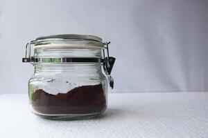 Jar of ground instant coffee on white background. photo