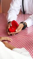 The man holding the red box in the shape of love is proposing to his girlfriend. photo