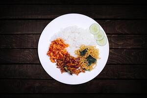 Spicy rice with fried noodles plus spicy chicken pieces. photo