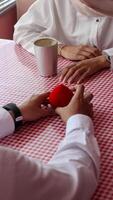 The man holding the red box in the shape of love is proposing to his girlfriend. photo