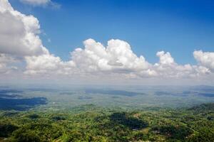 The view from the top of the hill with a stretch of blue sky and a bunch of white clouds. photo