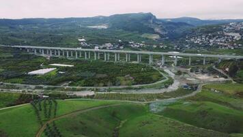 zangão do viaduto sobre vale, montanhas. luzes viaduto, agrícola Campos, viaduto, natural cenário, viaduto. foco em a infraestrutura, meio Ambiente contraste video