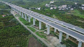 Drone view of highway viaduct over valley, mountains. Showcases infrastructure, mountain infrastructure, agricultural infrastructure. Highlights design, harmony with nature video