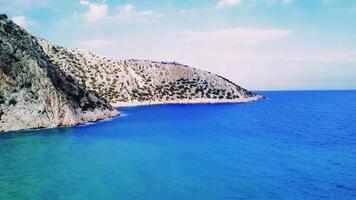 Aerial view showcases mountain, coastline meeting in Turkey bay. Landscape captures harmony between mountain, coastline. Scenic synergy of mountain, coastline visible video