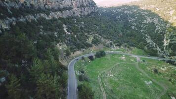 Drone captures car journey on mountain road through forest, showcasing road trip, driving. Emphasizes adventure of road trip, driving. Tailored for fans of road trip driving in natural settings video