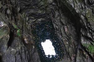 view of the sky through a deep granite underground well photo