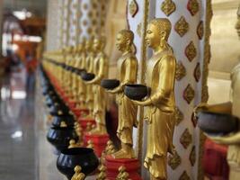 Buddha statues stand in horizontal rows. at Rat Prakong Tham Temple, Nonthaburi Province. photo