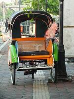 Surakarta, Central Java, Indonesia April 11, 2024. Vintage Becak vehicle is a traditional public transportation from Indonesia. photo