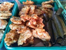 Traditional Indonesian snack Fried Bakwan made from wheat flour dough mixed with a little vegetables and savory spices. Sometimes eaten with lontong, which is rice cooked in rolled banana leaves. photo