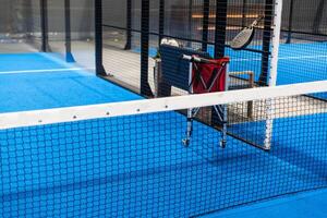 Paddle tennis. Paddel racket and ball in front of an outdoor court photo