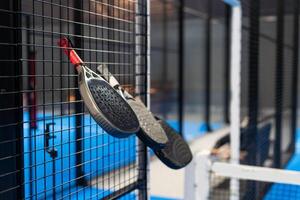Paddle tennis. Paddel racket and ball in front of an outdoor court photo