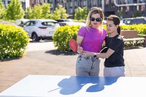 adulto mujer instructor enseñando niña jugar mesa tenis foto
