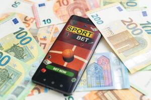 betting on sports, smart phone with working online betting mobile application photo