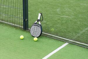 paddle tennis racket and balls on court photo