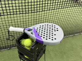 Background of padel racket and ball on artificial grass floor in outdoor court. Top view. photo