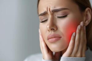 A woman holds her cheek while suffering from a toothache, depicting the discomfort and pain experienced during dental issues, emphasizing the need for oral health care and treatment photo