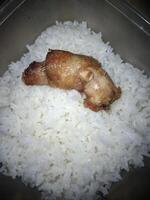 un pedazo de pollo cuello y fragante arroz en un caja foto