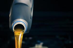 Pour engine oil from the lubricant bottle. Engine background, oil change shop engine service industry photo