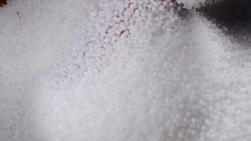 A woman mixes plastic granules with orange pigment to create colored plastic. Polymer composites are used in industry as raw materials for the production of various products video