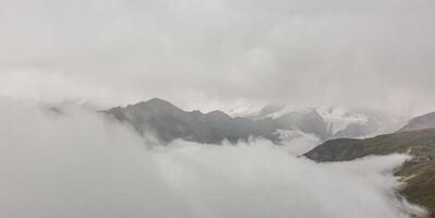Panorama of cloud layer from mountain top over Swiss alps photo
