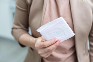 woman wearing a colored shirt holding a sanitary pad photo