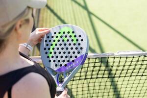 A girl with a paddle racket on an outdoor court. Concept of women playing paddle. Paddle sport. Ukraine Kyiv, April 02 2024 photo