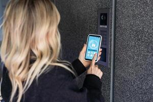 Smiling woman setting home security system with help of mobile application. photo