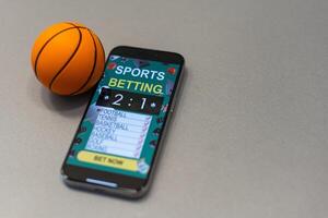 Sports betting website in a mobile phone screen, ball, money photo