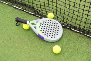 Paddle racket, next to the ball and on a carpet of the play area photo