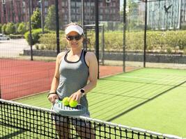 Happy female paddle tennis player during practice on outdoor court. Copy space. photo
