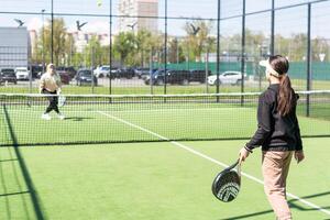 Young girls playing padel on a sunny day photo