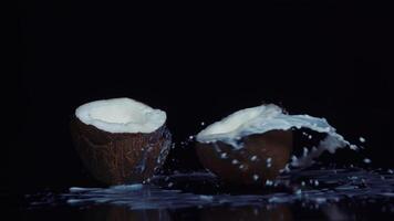 Coconut broken in slow motion on black background video