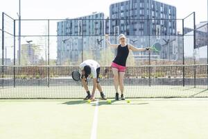 Young sporty woman and man playing padel together on same team photo