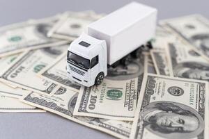 White toy truck lie on dollars, space for text. photo