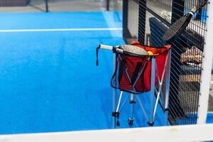 Paddle tennis. Paddel racket and ball in front of an outdoor court photo